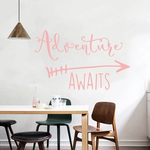 Pink Adventure Awaits wall decal with arrow and wings in a modern dining room setup