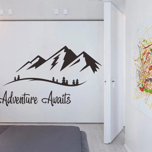Detail view of adventure awaits mountain vinyl wall decal on a modern white interior wall