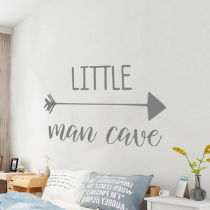 Detail showing grey Little Man Cave wall sticker with arrow on a minimalist white wall