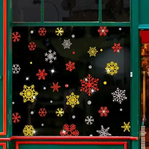 Detail showing red, gold and silver glitter snowflake window stickers on glass