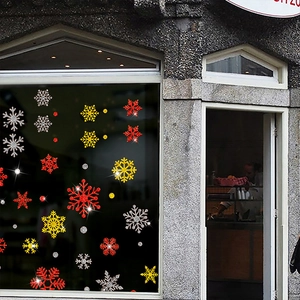 Glittery Christmas snowflake window stickers in red, gold and silver for holiday decor