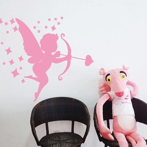 Sticker mural Cupidon rose avec décor d'étoiles sur mur blanc au-dessus de deux chaises