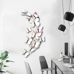 Detailed view of 3D white and pink magnetic butterfly wall stickers on a clean white wall