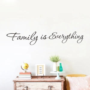 Detail von Family is Everything Wandtattoo in schwarzer Kursivschrift im Wohnzimmer