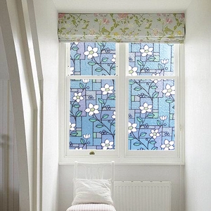 Detail of frosted window film featuring white floral patterns on a blue geometric base
