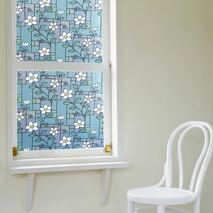 Detail of static cling window film featuring white floral patterns on a blue geometric background