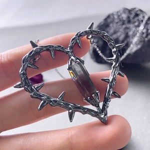 Gothic heart pendant necklace with thorn design and hexagonal crystal on dark stones