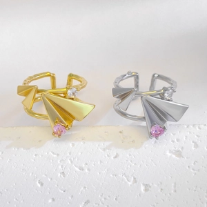 Detailed macro of branch texture band and pink heart zircon on paper plane ring