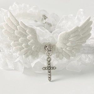 Detailed view of white gothic lace choker with angel wings and shimmering cross pendant