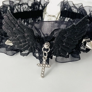 Detail of gothic black lace choker with silver spikes and a rhinestone cross pendant