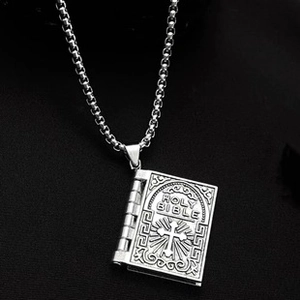 Detailed close-up of a silver Holy Bible book pendant with cross and sunburst engraving