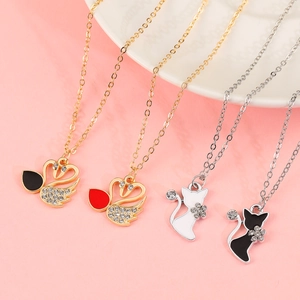 Close-up of heart swan and cat pendants with rhinestones on gold and silver chains