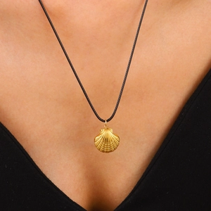 Golden scallop shell pendant necklace with black cord on model neck, summer ocean style