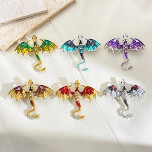 Vintage enamel dragon brooches with rhinestones in six colors on beige silk fabric