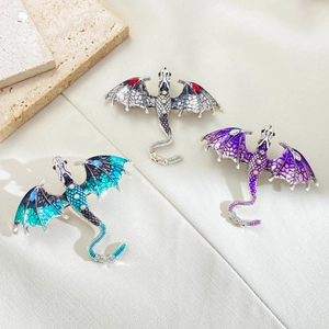 Vintage dragon brooches with enamel and rhinestones in green, black, and purple tones