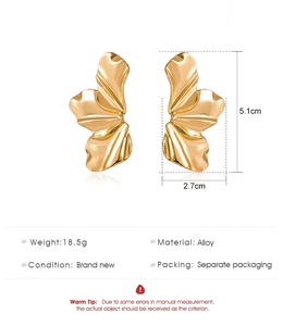 Macro detail of gold alloy petal earrings showing pleated texture and size dimensions
