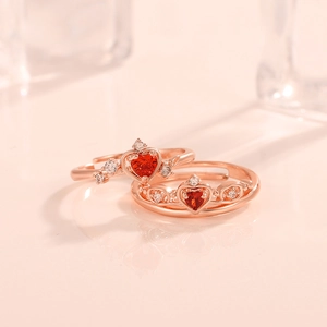 Nahaufnahme von roségoldenen Kronenringen mit roten Herzsteinen und weißen Zirkonia-Details