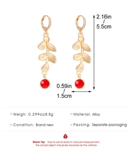 Detailed view of gold leaf earrings with red gemstone and precise size measurements