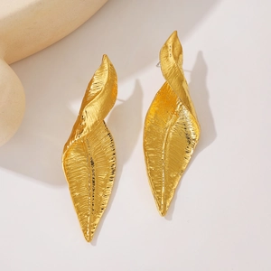 Close-up of golden leaf earrings with intricate bionic veins and twisted metal design