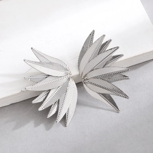Detail view of silver metal earrings showing textured leaf design and layered metal finish