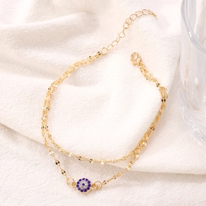 Elegantes goldfarbenes doppellagiges Fußkettchen mit glitzerndem blauem Evil Eye Anhänger