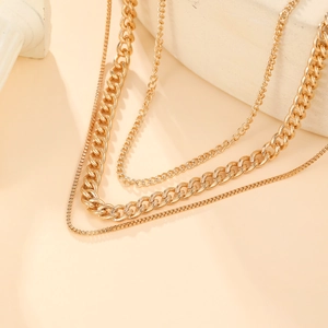 Three-layer punk style gold twist chain necklace set on minimalist stone background