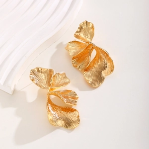 Detailed macro view of golden leaf earrings with realistic organic petal texture