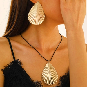 Exaggerated gold leaf jewelry set with large leaf earrings and pendant necklace