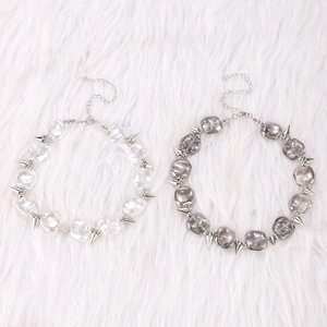 Punk style spiked choker necklace with iridescent and grey beads on white faux fur