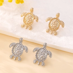 Minimalist turtle stud earrings set in gold and silver finish with detailed shell texture