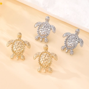 Detailed view of silver and gold plated sea turtle earrings with relief shell texture