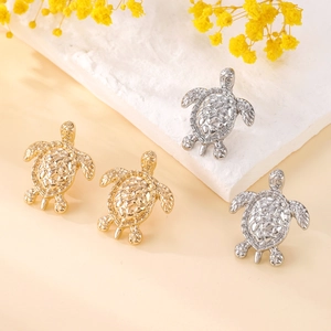 Minimalist sea turtle stud earrings in gold and silver finish with detailed shell texture