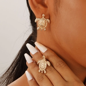 Minimalist golden turtle earrings for women featuring detailed shell patterns on a model