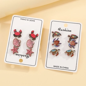 Detail view of ocean-themed wooden stud earrings set featuring crab, starfish and turtle