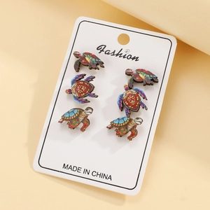 Three pairs of marine ocean turtle printed wooden stud earrings on a display card