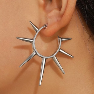 Nahaufnahme eines silbernen Spike-Creolen-Ohrrings mit Hochglanzfinish am Model-Ohr