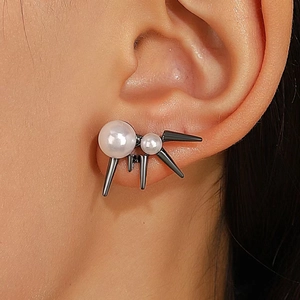 Nahaufnahme von Gothic-Punk-Ohrklemmen mit weißen Kunstperlen und schwarzen Metallspikes