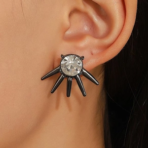 Nahaufnahme der gotischen Ohrstecker mit rundem Kristall und schwarzen Metall-Dornen
