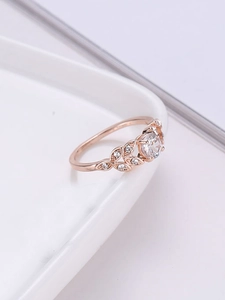 Macro shot of rose gold laurel leaf ring with round moissanite and micro-diamonds