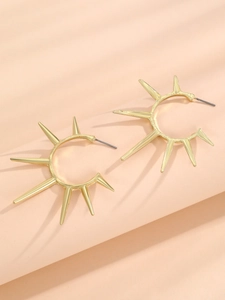 Detailaufnahme goldener Ohrstecker im Sonnenstrahl-Design mit markanten spitzen Zacken