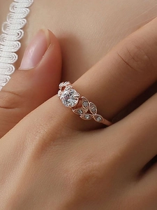 Close-up of laurel leaf moissanite ring with rose gold finish and round cut gemstone