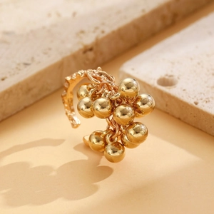 Detailed shot of gold textured ring featuring multiple small bead pendants on stone