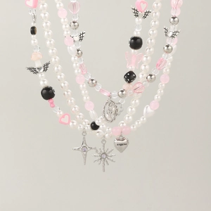 Detail of Y2K layered pearl necklaces with butterfly heart and cross charms