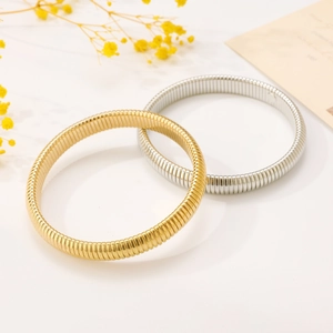 Detail of minimalist elastic metal bracelets with golden and silver ribbed texture finishes
