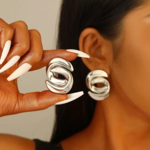 Abstract silver spiral geometric stud earrings shown on model for modern fashion look
