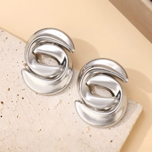 Detailed close-up of silver abstract streamlined earrings with high-polish mirror finish