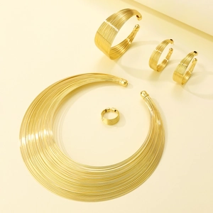 Detail of gold multilayered jewelry set with necklace, bracelet, earrings and open ring