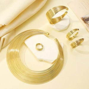Gold multi-layer choker necklace and jewelry set on elegant stone display stands