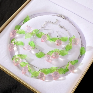 Detalle de set de joyas de fresa con collar, pulsera y pendientes en caja de regalo