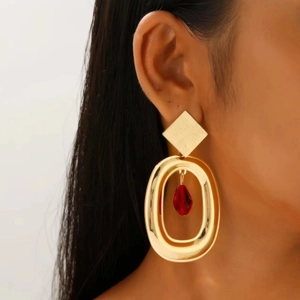 Retro geometric gold earrings with oversized oval ring and red gemstone drop on model